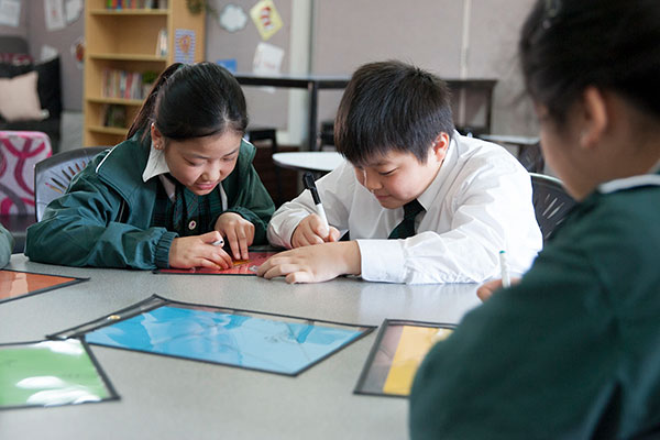 Students work on math problems at St Peter Chanel Catholic Primary School Regents Park