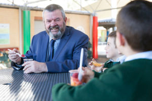 St Peter Chanel Catholic Primary School Regents Park principal sitting and enjoying breakfast with students in the playground
